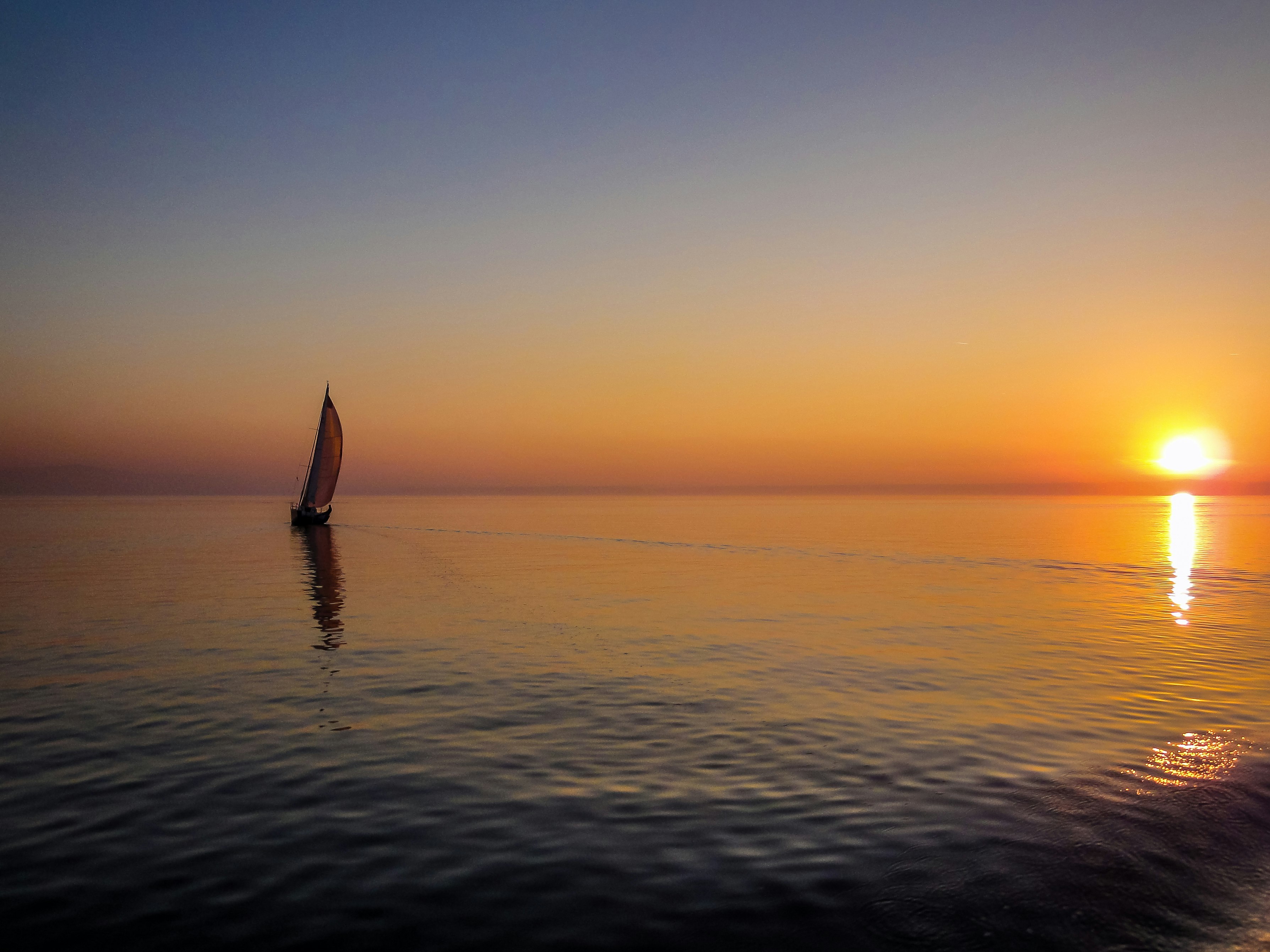 silhouette of sail boat on body of water